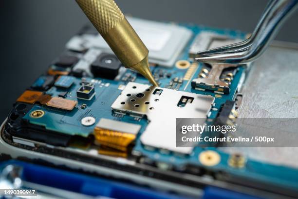 technician repairing inside of mobile phone by soldering iron integrated circuit the concept of da,romania - disassembling stock pictures, royalty-free photos & images