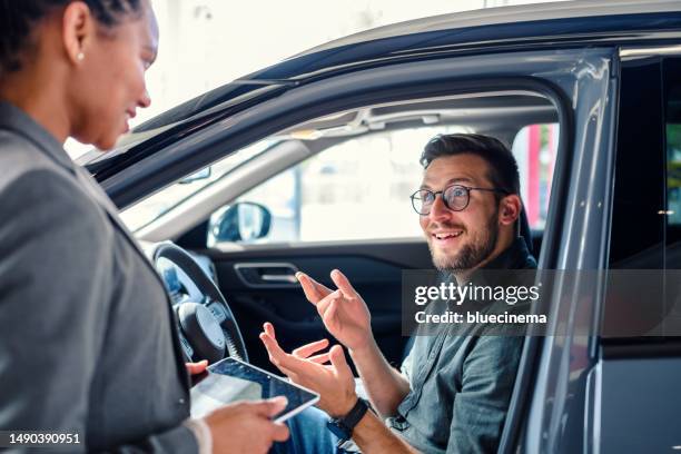 saleswoman helping the male customer to choose a new car - conversation car bildbanksfoton och bilder