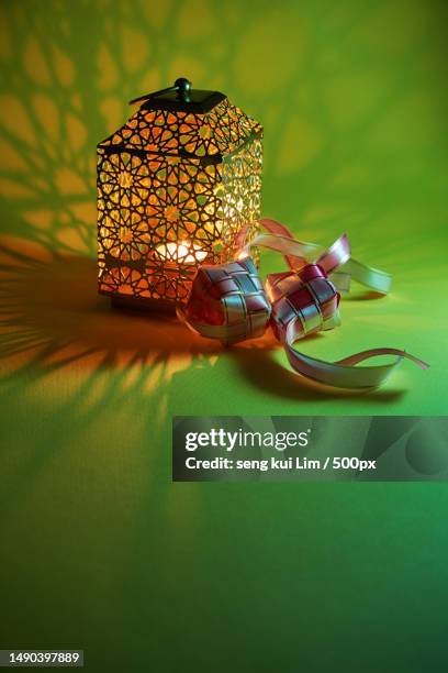 arabic lantern on the table with light ray and ribbon ketupat,malaysia - ketupat stock pictures, royalty-free photos & images
