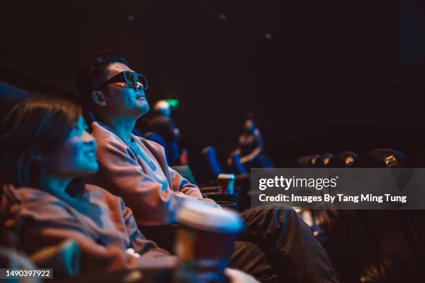 dad & daughter with 3d glasses getting ready to enjoy a 3d movie in movie theatre - dark premiere stock-fotos und bilder