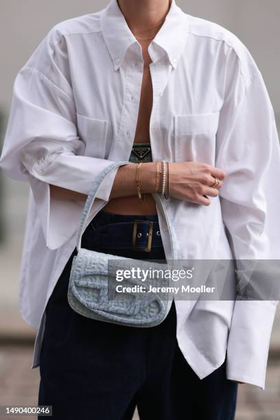 Nadine Berneis seen wearing a Prada denim black logo bra, Diesel 1DR mini denim baby blue handbag, Closed wide leg, dark blue denim belt pants, black...