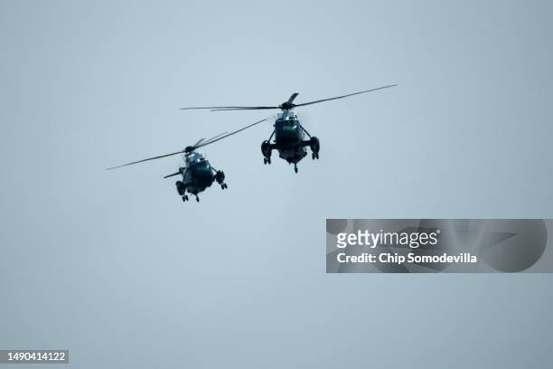 Helicopters with the HMX-1 squadron escort Marine One with U.S. President Joe Biden and first lady Jill Biden on board as they return to the White...