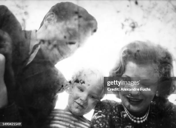 Actress Gena Rowlands with husband, actor/director John Cassavetes, and son, Nick Cassavetes, take a portrait of their reflection on a table at their...