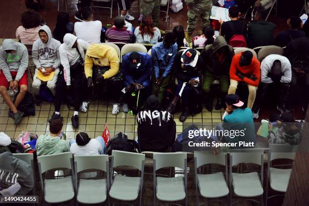 Newly arrived asylum seekers wait in a holding area at the Port Authority bus terminal before being sent off to area shelters and hotels on May 15,...