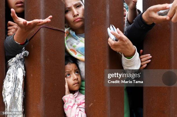 Ecuadorian mother Miriam stands with her daughter Aylin as they await volunteer assistance while stuck in a makeshift camp amongst border walls,...