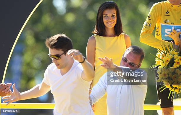 Bernard Hinault throws a podium invader off the stage after the twentieth and final stage of the 2012 Tour de France, from Rambouillet to the...