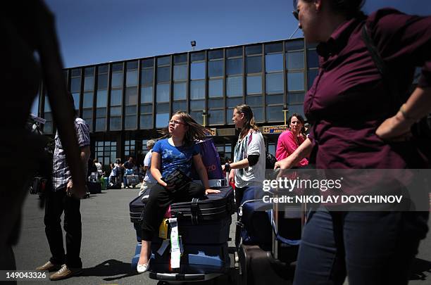 Diana Simeonova A girl sits on a luggage after arriving at the Burgas Airport on July 21, 2012. Sunbathing, gambling and bar crawling it's business...