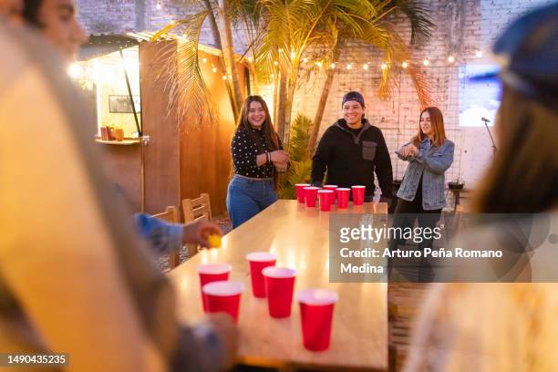 friends playing beer pong all excited - beirut stockfoto's en -beelden