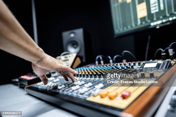 primer plano de una mano humana usando un mezclador de sonido en el estudio de grabación - equipo editorial fotografías e imágenes de stock