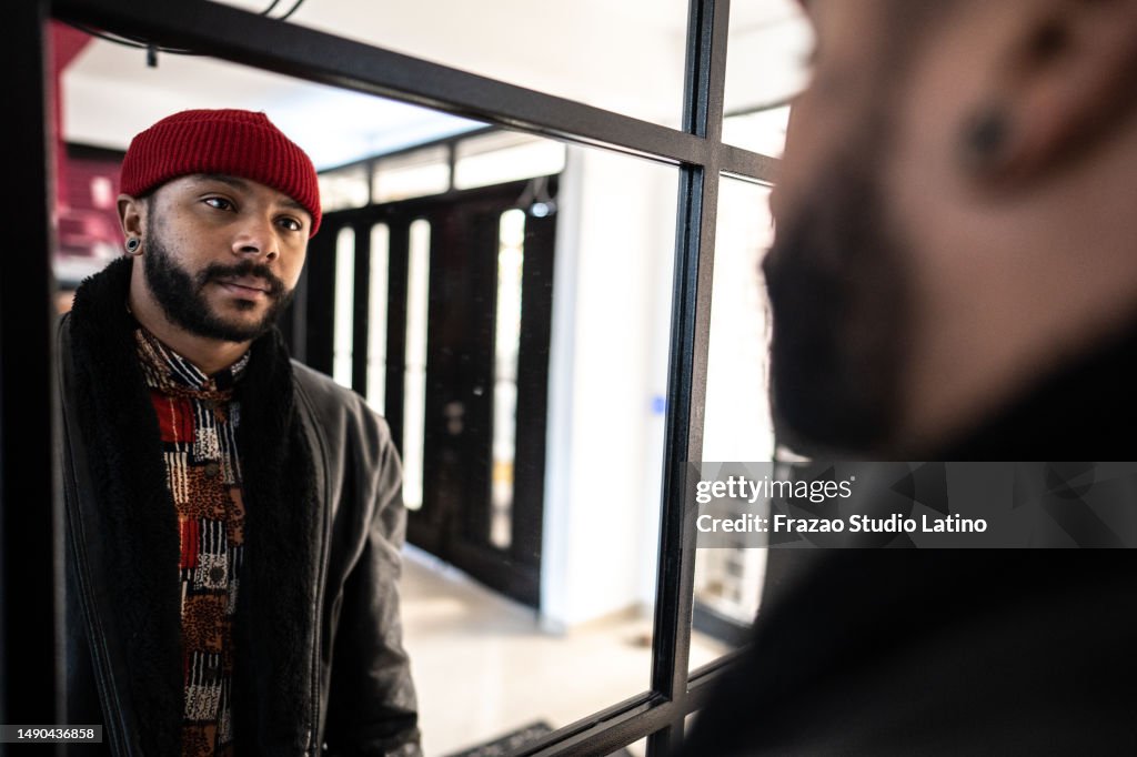 Mid adult man looking to his reflection in mirror at home