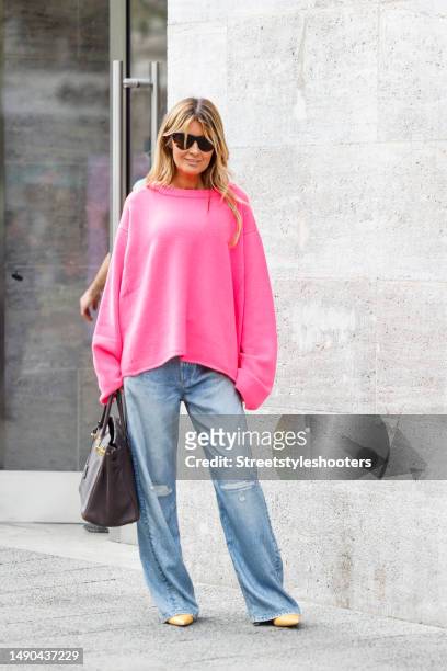 Influencer Gitta Banko, wearing a pink colored oversize cashmere pullover by Simone Bruns, Jeans by Rag and Bone, light orange colored pumps by...