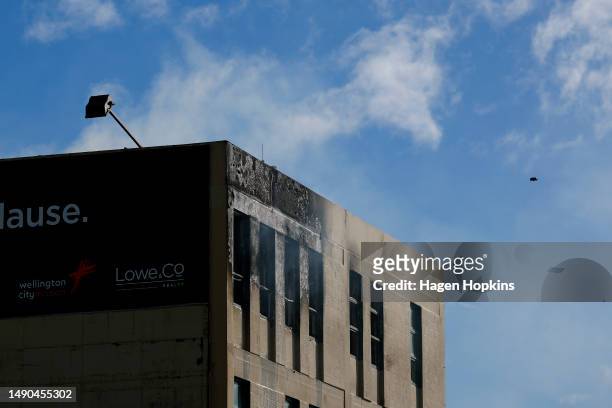 Smoke escapes as a drone surveys the scene after a fire at Loafers Lodge on May 16, 2023 in Wellington, New Zealand. At least 10 people are dead and...
