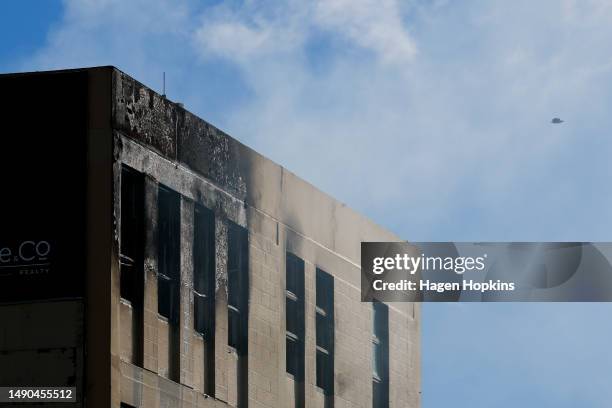 Smoke escapes out of windows as a drone surveys the scene after a fire at Loafers Lodge on May 16, 2023 in Wellington, New Zealand. At least 10...