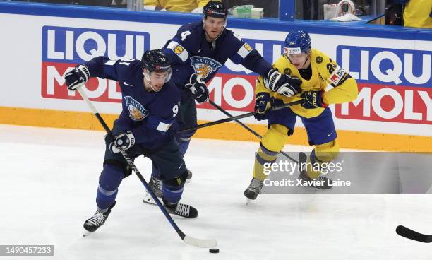 Juho Lammokko of Team Finland controls the puck alongside teammate Mikko Lehtonen and Lucas Raymond of Team Sweden during the 2023 IIHF Ice Hockey...