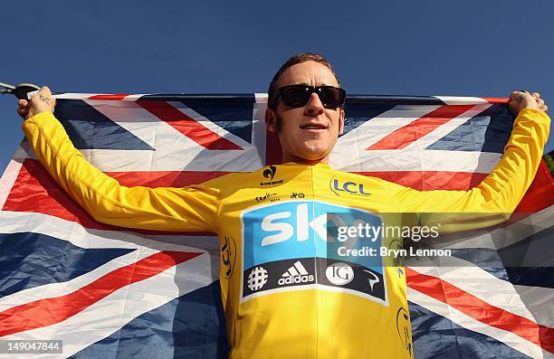 Bradley Wiggins of Great Britain and SKY Procycling celebrates on a processional lap after winning the 2012 Tour de France after the twentieth and...