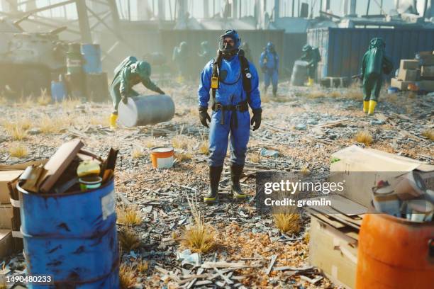 männer im schutzanzug reinigen verschmutzte umwelt - hazmat suit stock-fotos und bilder
