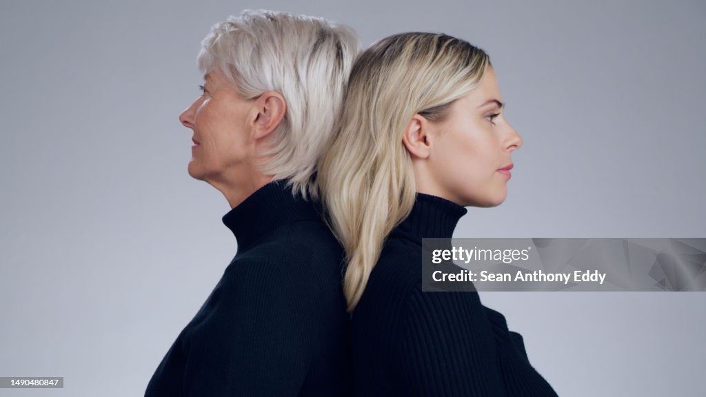 Ernst, Mode und Profil von Mutter und Tochter isoliert auf einem grauen Studiohintergrund. Rücken an Rücken und starke ältere Mutter mit einem Mädchen, das stilvoll und modisch auf einem Hintergrund aussieht