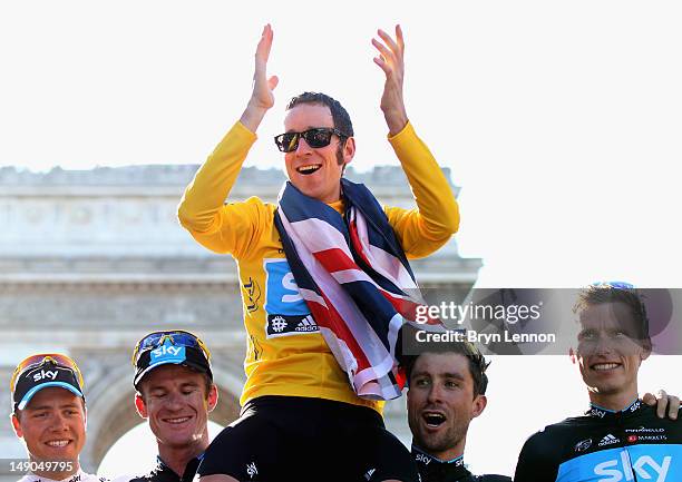 Bradley Wiggins of Great Britain and SKY Procycling celebrates on a processional lap alongside teammates Edvald Boasson Hagen, Michael Rogers,...