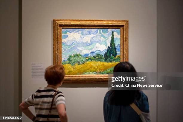 People look at a painting during the media preview of "Van Gogh's Cypresses" Exhibition at the Metropolitan Museum of Art on May 15, 2023 in New York...