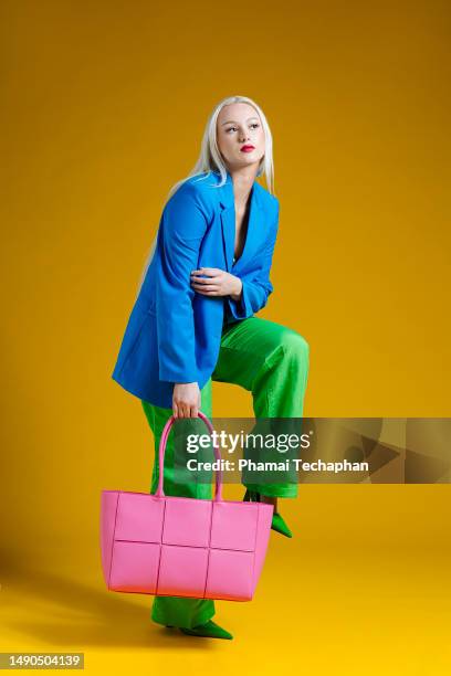 fashionable woman on plain background - bunte handtasche stock-fotos und bilder