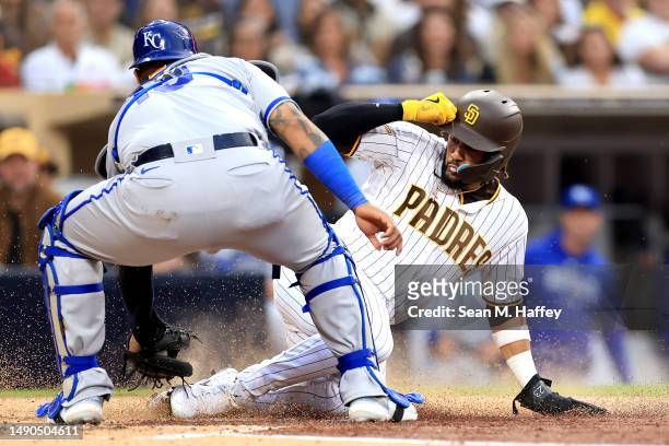 Salvador Perez of the Kansas City Royals tags out Fernando Tatis Jr. #23 on a fielders choice hit by Manny Machado of the San Diego Padres during the...