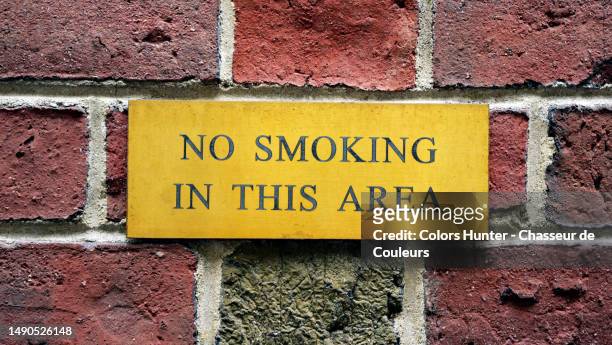 "no smoking in this area" engraved on a metal plate on the facade of a residential building in manhattan, new york city, united states - cigar texture stock pictures, royalty-free photos & images