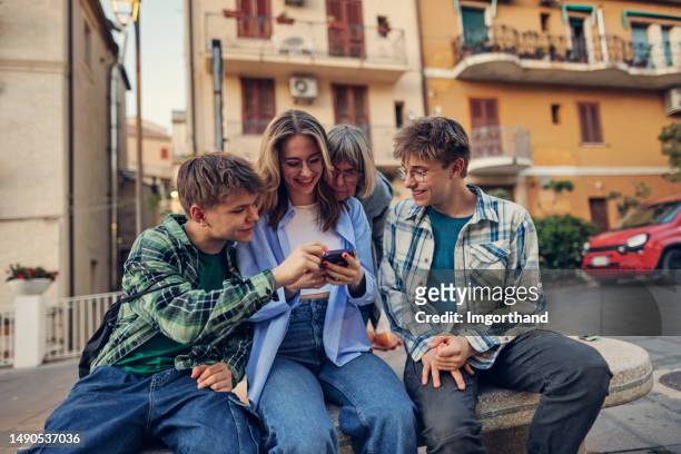 grandmother and happy teenagers enjoying time together in the town streets - boys and girls town stock pictures, royalty-free photos & images