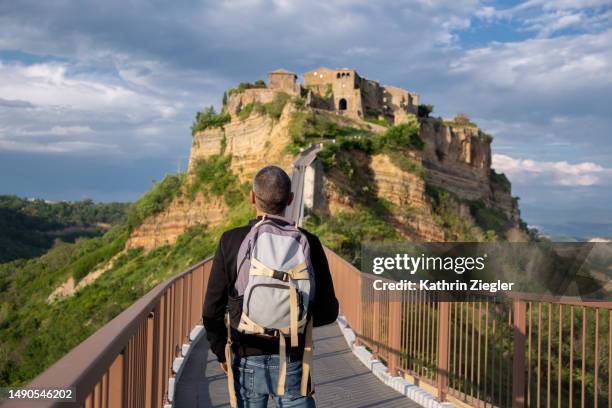 man on the footbridge to civita di bagnoregio, "the dying city" - provinsen viterbo bildbanksfoton och bilder