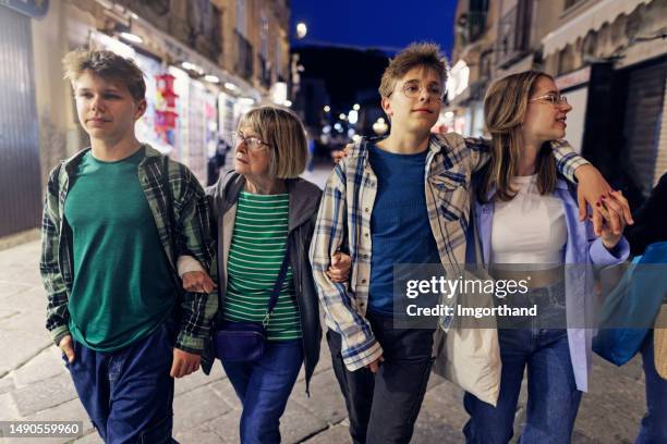 multi generation family walking in night streets of tropea - boys and girls town stockfoto's en -beelden