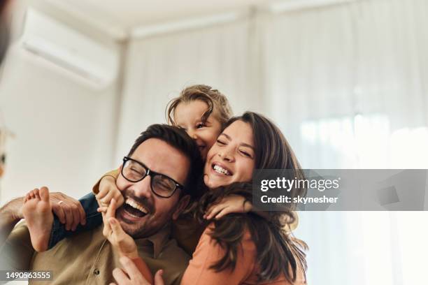 fille joyeuse s’amusant avec ses parents à la maison. - happy family at home photos et images de collection