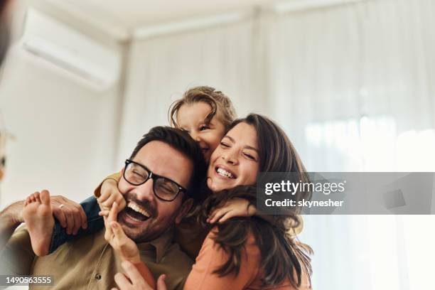 cheerful girl having fun with her parents at home. - kids having fun indoors stock pictures, royalty-free photos & images