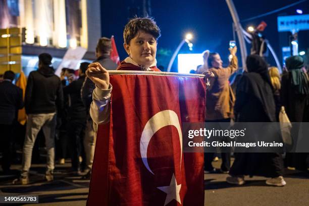 Erdogan’s supporters hold the flags of Turkey during a rally after the closing of polling stations near the headquarters of the current president’s...