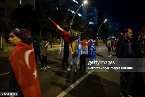 Erdogan’s supporters hold the flags of Turkey during a rally after the closing of polling stations near the headquarters of the current president’s...