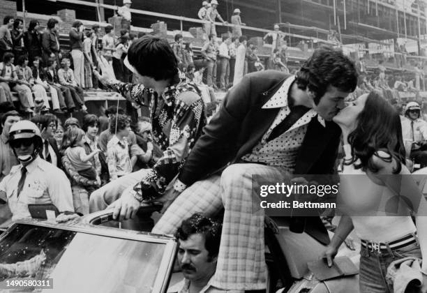 The Montreal Canadiens' Yvon Lambert kisses a supporter at the Stanley Cup parade, while team mate Guy Lapointe waves to construction workers on St...