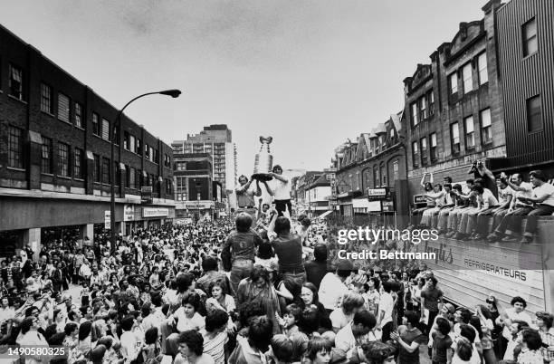 Co-Captains Yvan Cournoyer and Serge Savard hold up the Stanley Cup as the Montreal Canadiens ice hockey team parades through Montreal, Canada, May...