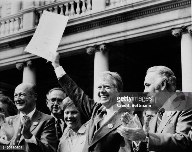 President Jimmy Carter holds up a document outside New York's City Hall after signing the New York City Loan Guarantee Act of 1978, August 8th 1978....