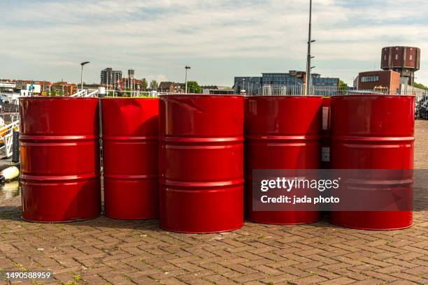 five red oil barrels stand on the quay - borrel stock pictures, royalty-free photos & images