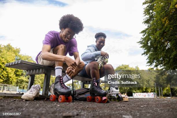 tying rollerskate laces - roller skates stock pictures, royalty-free photos & images