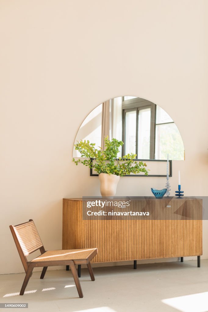 Stylish wooden chair next to a sideboard in a modern living room