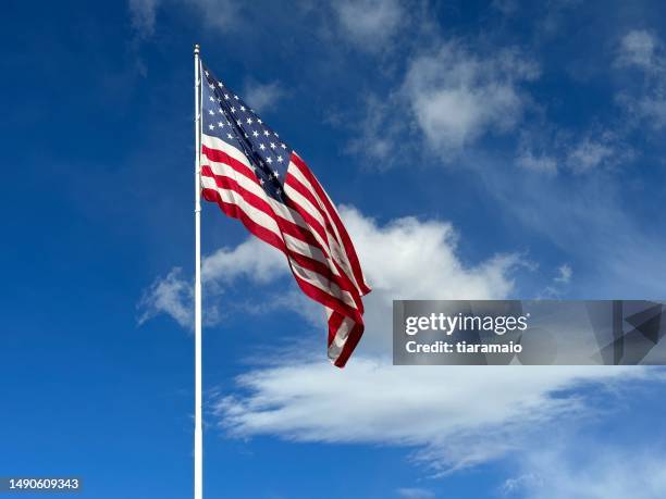 american flag blowing in the wind with a partly cloudy blue sky, usa - amerikanische flagge stock-fotos und bilder