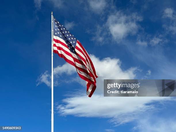 american flag blowing in the wind with a partly cloudy blue sky, usa - american flag jpg stock pictures, royalty-free photos & images