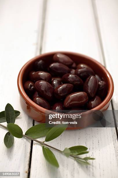 olives on a table with branch - black olive stock pictures, royalty-free photos & images