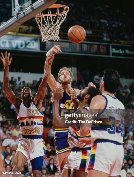 Mark Eaton, Center for the Utah Jazz and Fat Lever, Point Guard and Shooting Guard for the Denver Nuggets challenge for the basketball during their...