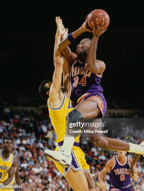 Tim Perry, Power Forward and Center for the Phoenix Suns drives to the basket over Vlade Divac, Center for the Los Angeles Lakers during Game 2 of...