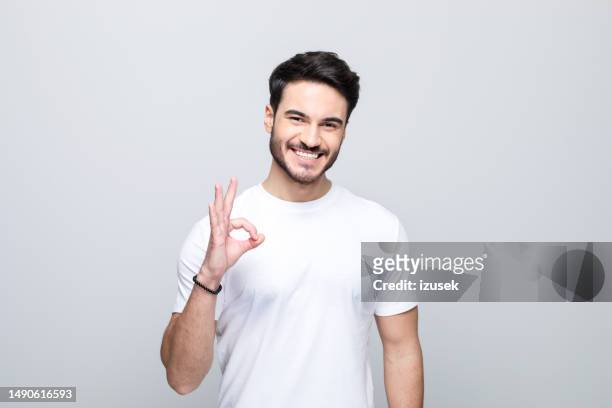 portrait of pleased young man - white t shirt studio stock pictures, royalty-free photos & images