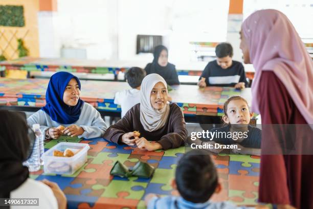 elementary school pupils with teacher in canteen, eating breakfast and having fun - schoolgirl stock pictures, royalty-free photos & images