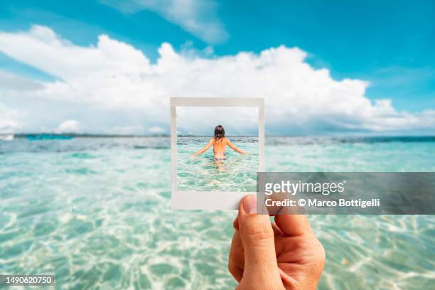 personal perspective of polaroid picture overlapping woman in tropical waters - remembrance imagens e fotografias de stock