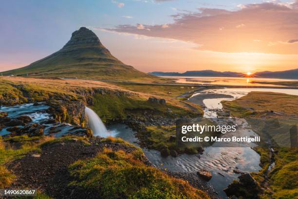 mount kirkjufell and kirkjufellsfoss waterfall at sunrise, iceland - westfjorde island stock-fotos und bilder