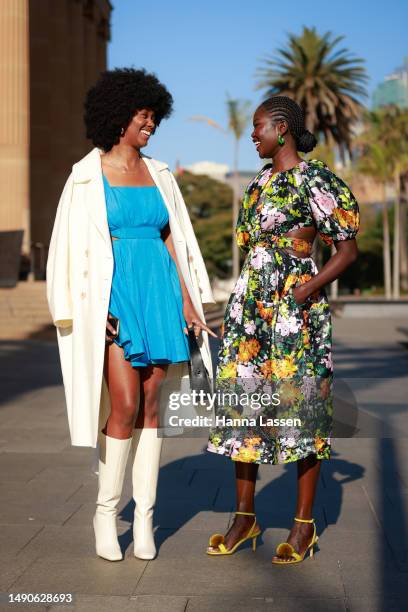 Aiyana Alexander wearing blue Aje dress, white coat and white leather boots and Malaan Ajang wearing floral printed Aje dress at Afterpay Australian...