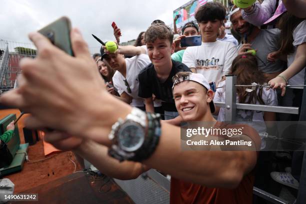 Holger Rune of Denmark takes photos with fans after winning against Alexei Popyrin of Australia during their Men's Singles fourth round match during...